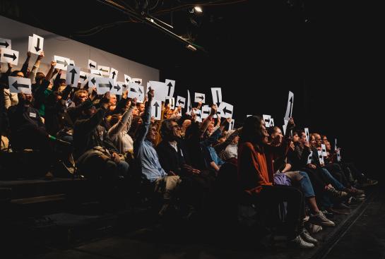 Un public tient des affiches
