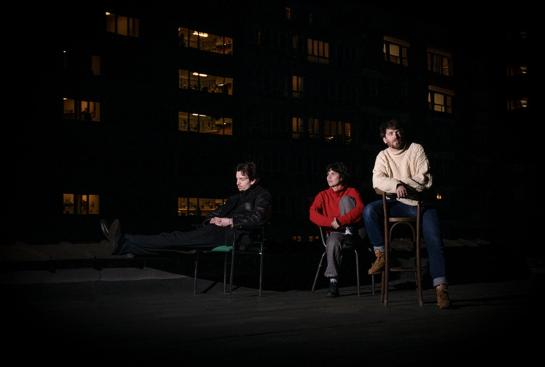Trois personnes sur un toit la nuit
