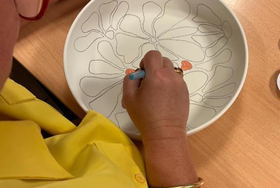 Une personne dessine sur de la céramique