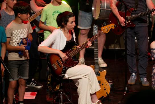 Une bassiste entourée de musiciens