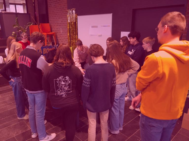 Des ados debout autour d'une table