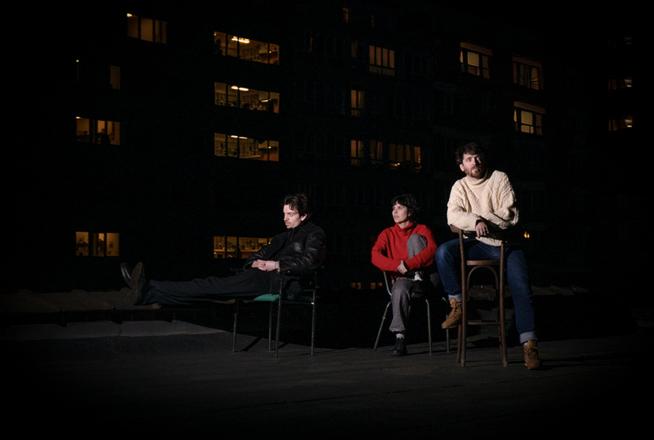Trois personnes sur un toit la nuit