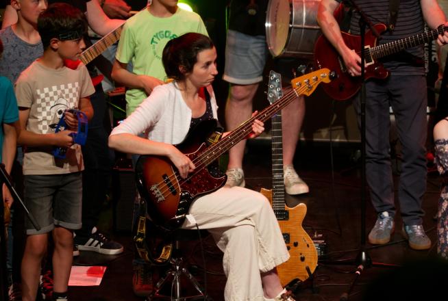 Une bassiste entourée de musiciens