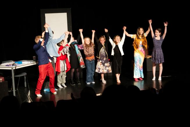 Un groupe d'enfants salue le public